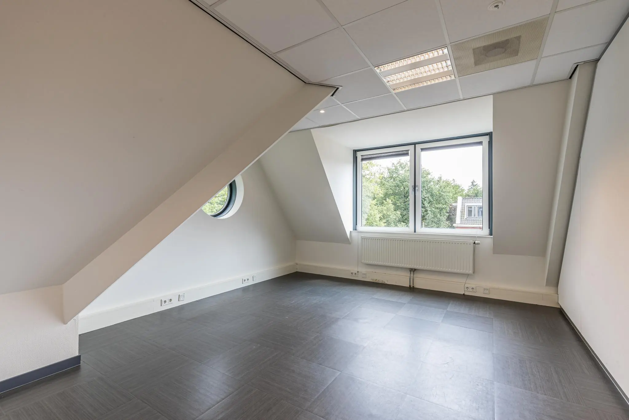 Leeg kantoorruimte met schuin plafond en ramen aan de Laan Blussé van Oud-Alblas.